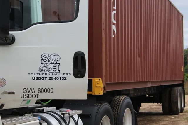 Close-up of the Southern Haulers door logo with USDOT 2840132 against a red coupled container, 2024